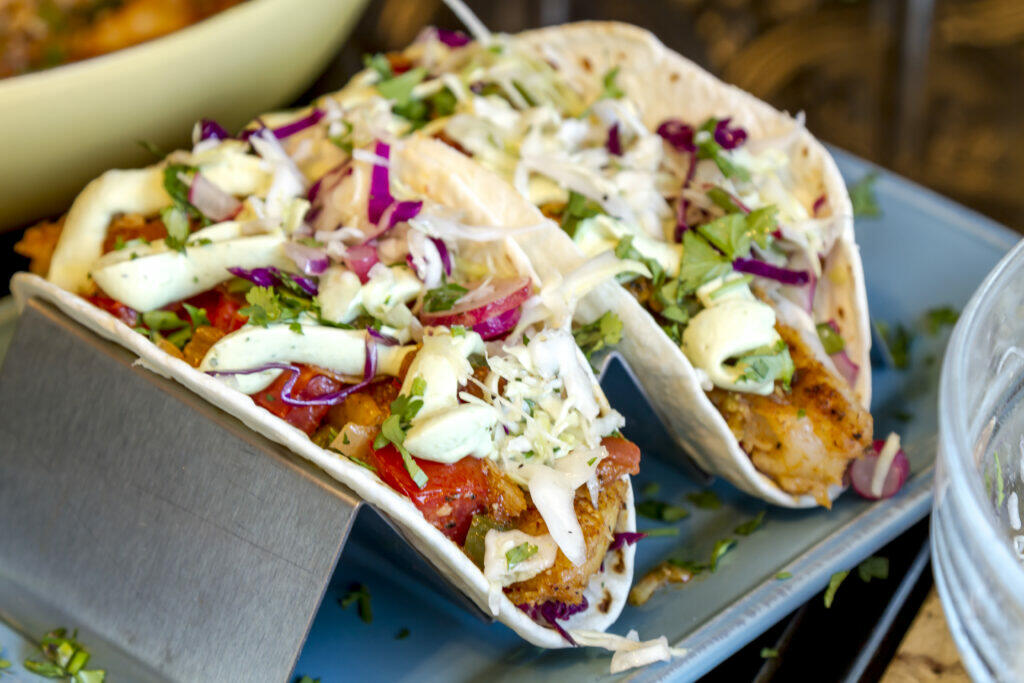 Tacos de pescado en salsa de chipotle con pepitas y aguacate frito.